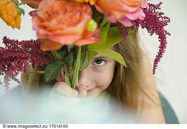 Girl (6-7) holding flower bouquet