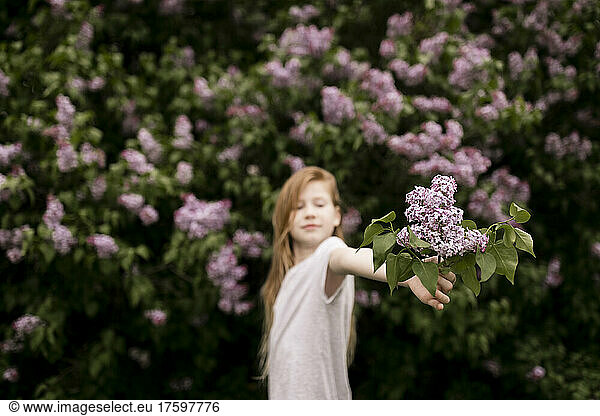 Girl holding lilac flowers in nature