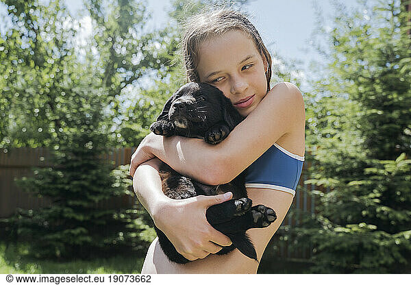 Girl holding puppy in back yard