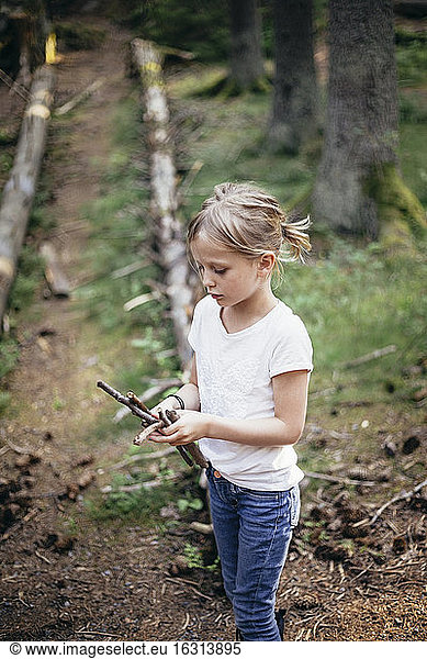 Girl holding sticks in forest