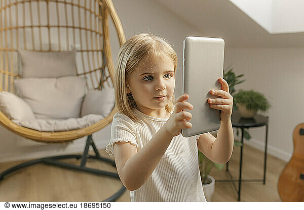 Girl holding tablet PC at home