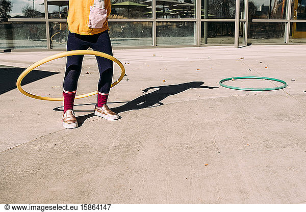 girl hula hooping on a patio on a summer day