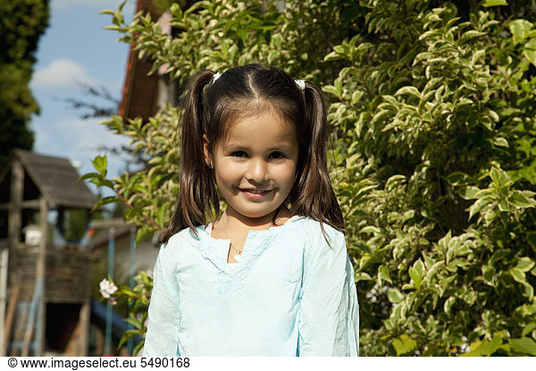 Girl in garden  smiling  portrait