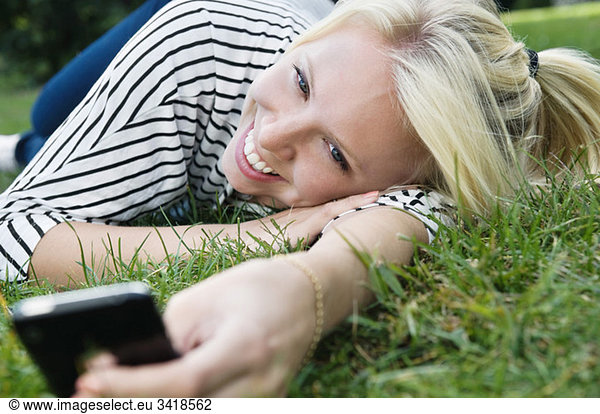 Girl in grass with telephone