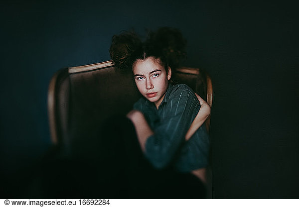 Girl in green chair curled up