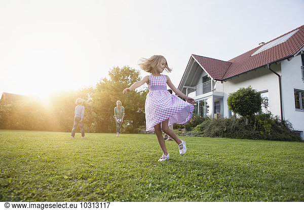 Girl in motion with family in garden