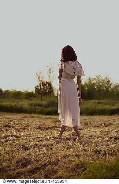 Girl in romantic dress back in countryside