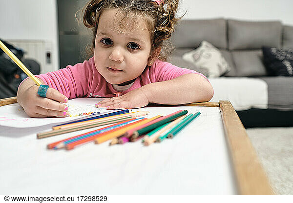 girl is sitting at her desk to draw with her pencils.