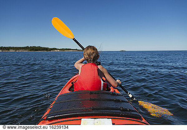 Girl kayaking on sea