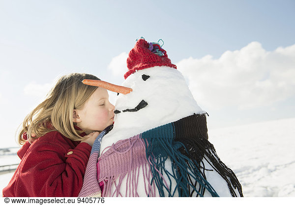 Girl kissing snowman