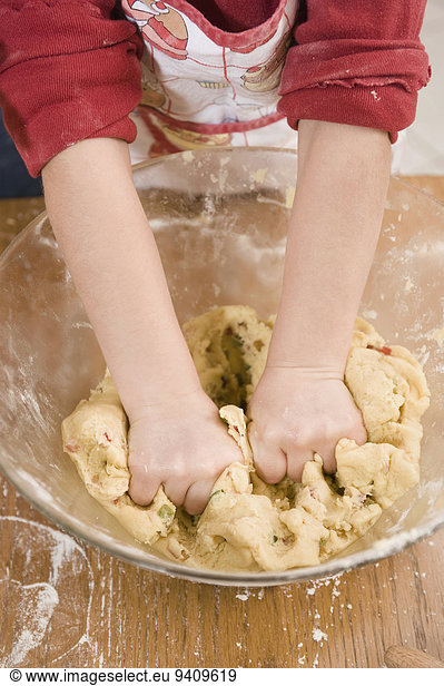Girl kneading dough in bowl for cookies