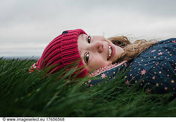 girl laying in the grass smiling relaxing in the sun