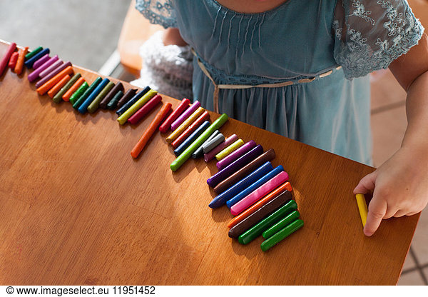 Girl lining up crayons in a row