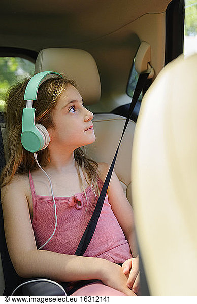 Girl (6-7) listening to music in car