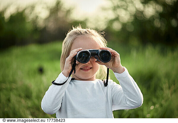 Girl looking through binoculars on weekend