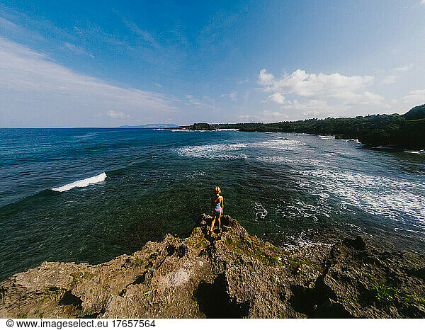 Girl looks over deep blue ocean landscape