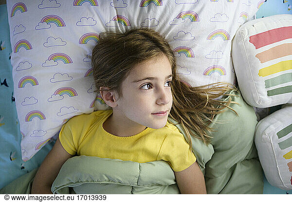 Girl (6-7) lying in bed