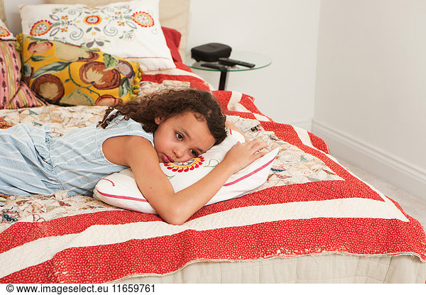 Girl lying on front on bed