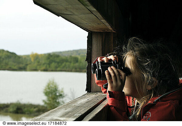 Girl observing birds through binoculars  ?tang de la V?ronne  Etangs du Malsaucy et de la V?ronne trail  Sermamagny  Territoire de Belfort  France