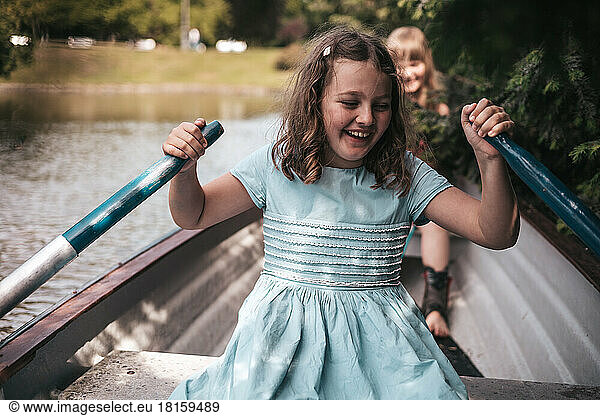 girl on a boat rowing oars  vacation in the village