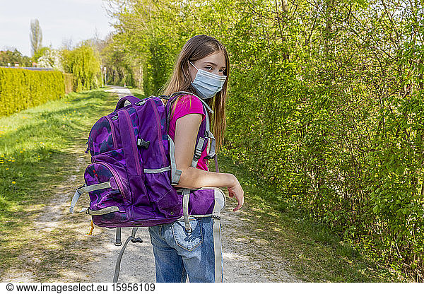 Girl on her way to school with protective mask