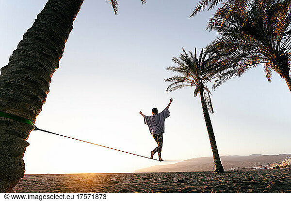 Girl on the balance rope  at sunset  beach in the background