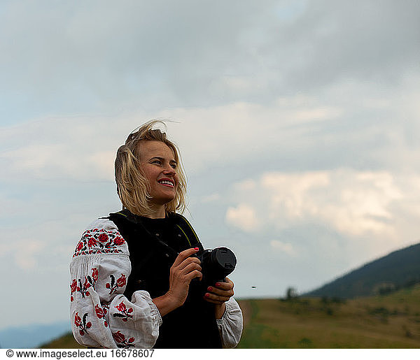 girl photographer in the summer high in the mountains in the Ukrainian embroidery