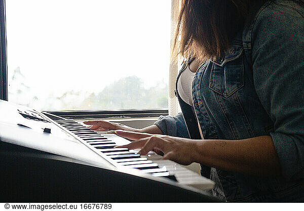 Girl playing piano with hands close up