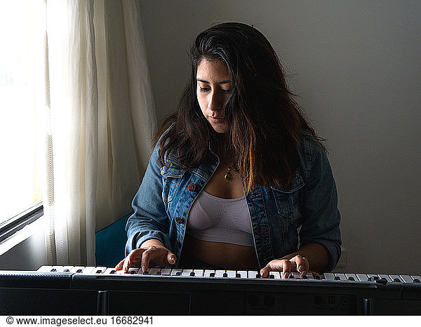 Girl playing piano with sunlight