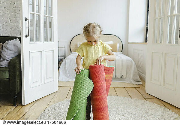 Girl playing with exercise mats at home