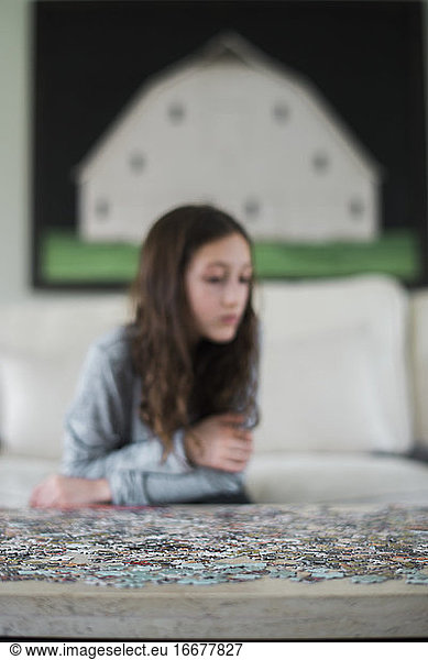 Girl playing with jigsaw puzzle inside