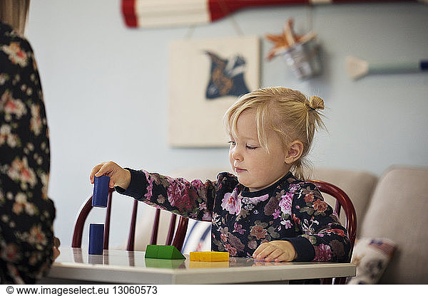 Girl playing with toy block at preschool