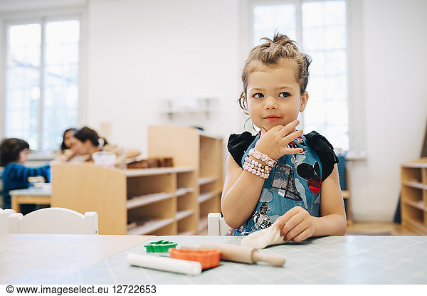 Girl playing with toys at table in child care classroom