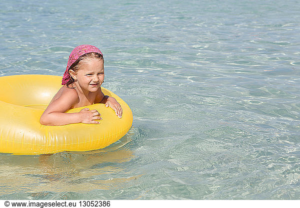Girl playing with yellow inflatable in sea  San Vito  Sicily  Italy