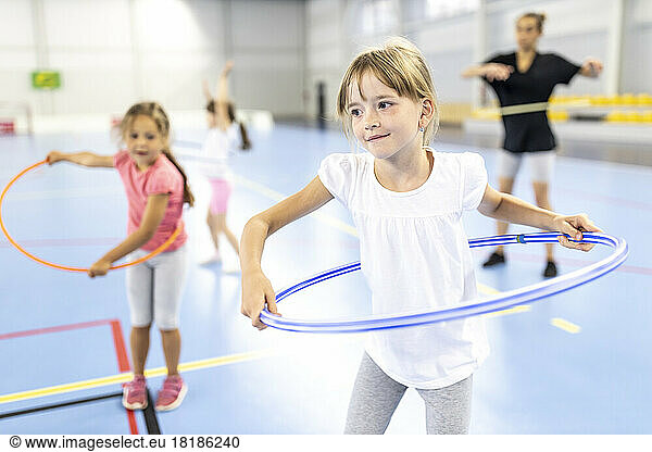 Girl practicing hula hoop at school sports court