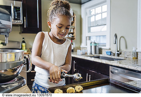 Girl preparing chocolate chip cookies in kitchen