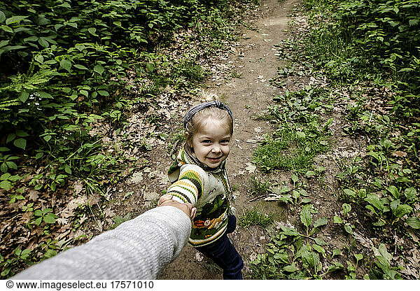 Girl pulling mom in the woods on a hike