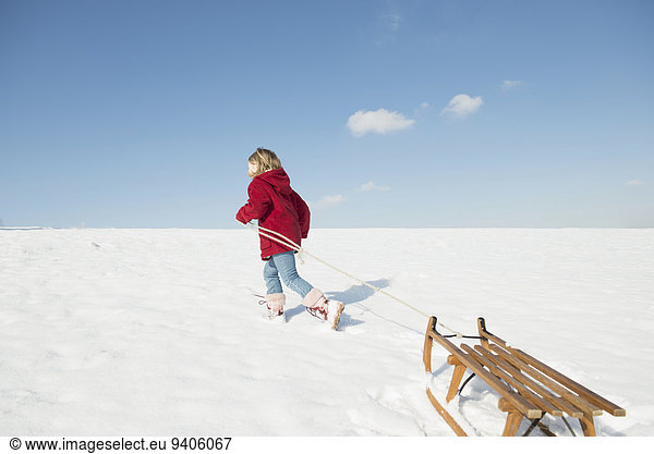 Girl pulling sledge in snow