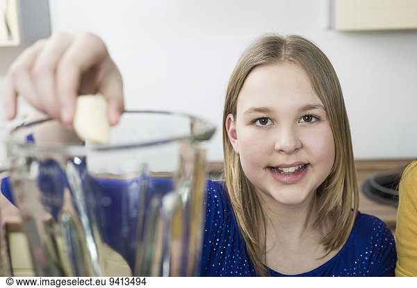 Girl putting fruit in blender