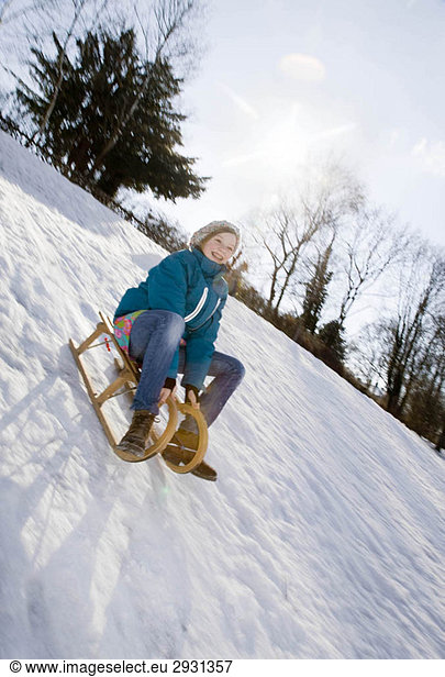 Girl riding a sledge in snow