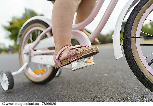 Girl riding bicycle on road