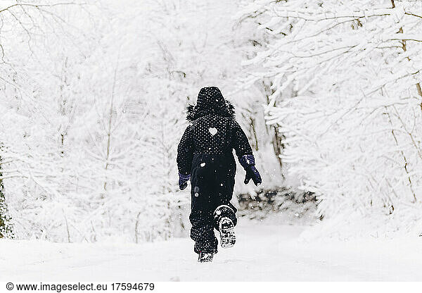 Girl running in snowy winter forest