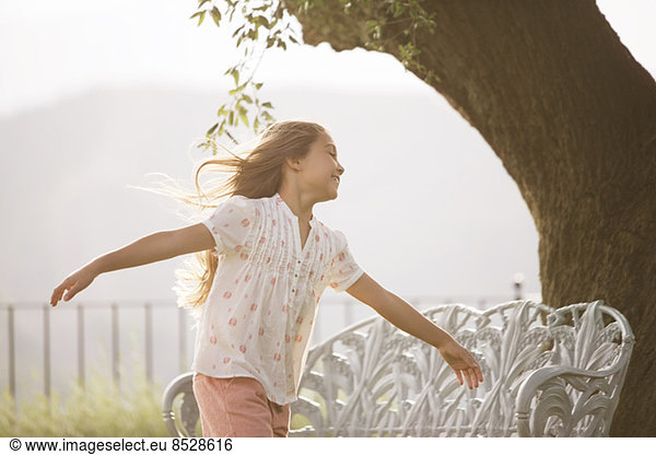 Girl running with arms outstretched