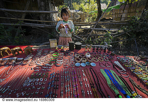 Girl selling touristic souvenirs on street market in village  La