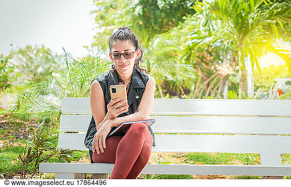 Girl sitting on a bench checking her cell phone