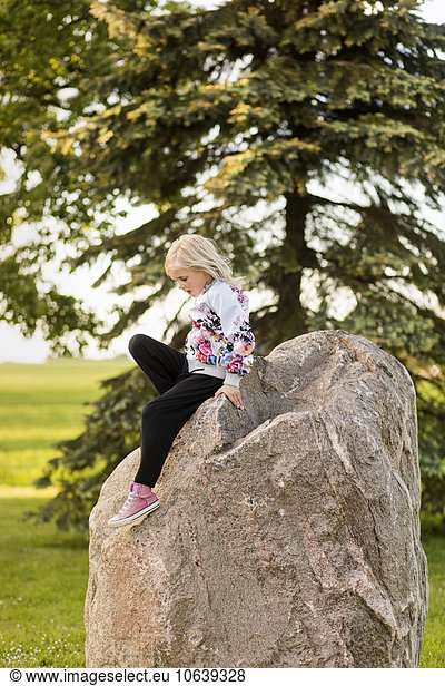 Girl sitting on rock at field
