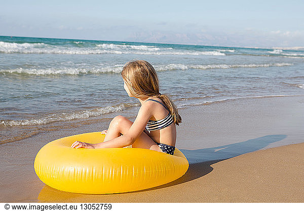Girl sitting on yellow inflatable at beach  Castellammare del Golfo  Sicily  Italy