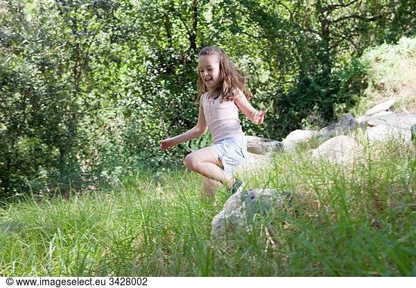Girl skipping through grass