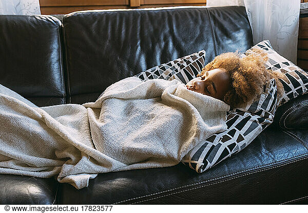 Girl sleeping on sofa at home