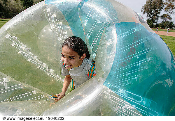 Girl smiles while inside an inflatable bubble